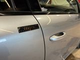 a silver car with a sticker on the side of it ' s door