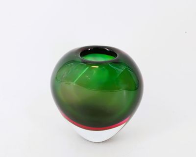 un vase en verre vert orné d'une bande rouge