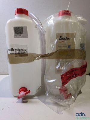 une bouteille et un récipient contenant un liquide posés sur un plan de travail