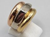 a close up of a gold and silver ring on a white surface