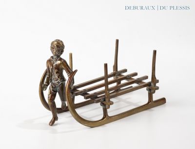 a bronze figurine of a boy on a sled