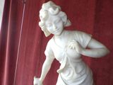 a statue of a woman holding a cat on a table