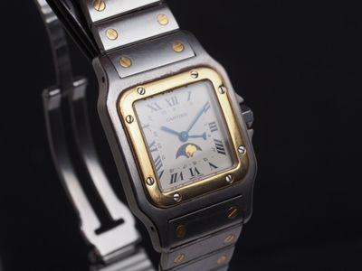 une montre-bracelet argentée et dorée sur fond noir