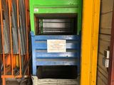 une pile de caisses dans un entrepôt, sur laquelle est accrochée une pancarte