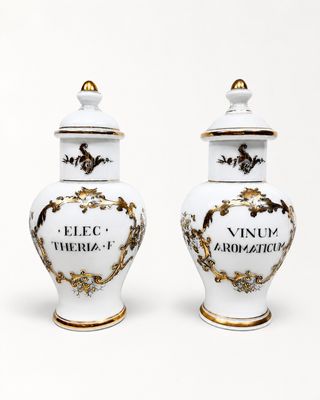 une paire de vases blancs et dorés portant les noms de différents pays