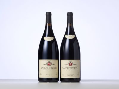 deux bouteilles de vin posées sur une table l'une à côté de l'autre