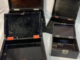 trois valises ouvertes posées sur un lit recouvert d'un drap blanc