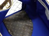 a blue bag with a brown handle and a brown handle