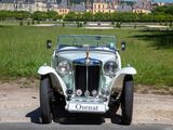 a white vintage car parked on the side of the road