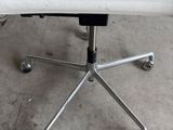 a white desk chair with wheels on a concrete floor
