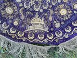 un tissu violet orné de motifs dorés et argentés
