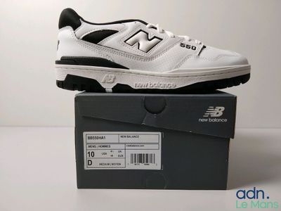 Les chaussures New Balance sont dans la boîte posée sur la table.
