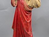 une statue de Jésus tenant une croix, posée sur un socle