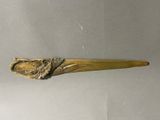une cuillère en or ornée d'un oiseau, posée sur une table