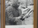 framed photograph of a man reading a newspaper on a sidewalk