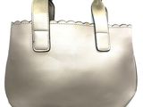beige leather handbag with scalloped edges on a white background