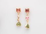 une paire de boucles d'oreilles en tourmaline rose et verte posées sur un fond blanc