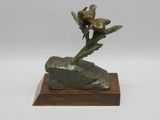 sculpture en bronze représentant une fleur posée sur un rocher, sur fond blanc