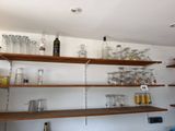 many glasses and bottles on the shelves in the kitchen