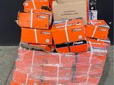 a pile of orange boxes on a pallet in front of a black wall