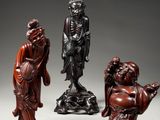 a group of four carved wood figures of buddhas