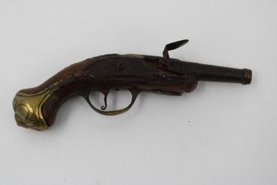 un vieux pistolet posé sur une surface blanche