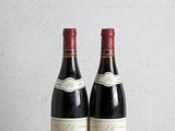 two bottles of wine sitting on top of a wooden table