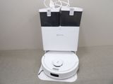 des toilettes blanches surmontées de deux poubelles noires et blanches
