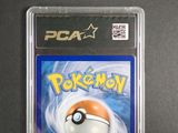 the pokemon card is in a plastic holder on a table