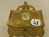an antique brass box with a picture of a woman on it