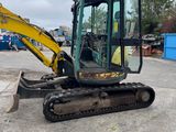 an image of a small excavator parked in a parking lot