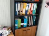 a desk with a chair and bookshelf in the corner