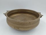 an old brown bowl sitting on top of a white table
