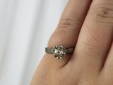 a woman ' s hand with a diamond ring on it