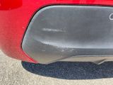 a close up of a red car ' s rear bumper