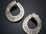 une paire de boucles d'oreilles en or et diamants sur une surface noire