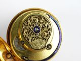 a gold ring with a blue stone inside of it