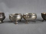 three silver bowls with handles and handles sitting next to each other