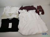 une robe blanche, une chemise noire et une paire de chaussures rouges posées sur une table