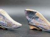 two pairs of shoes are sitting on top of a black surface