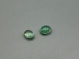 deux perles de verre vertes posées sur une table