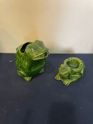 deux grenouilles en céramique verte posées sur une table