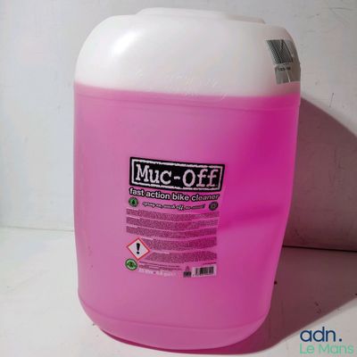 une cruche rose contenant un liquide, posée sur une surface blanche