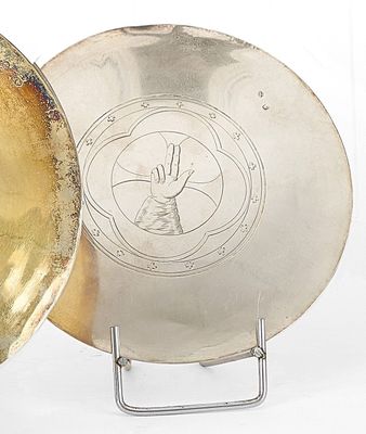 une assiette en argent sur laquelle est représentée une main et une assiette en argent sur laquelle est représentée une main