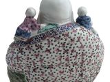 a figurine of three people sitting on top of a pillow