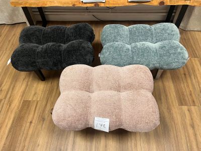 plusieurs coussins de différentes couleurs posés sur un parquet, devant une table