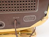 a close up of a brown and gold radio on a stand