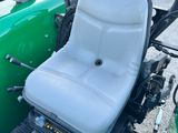 un tracteur vert avec un siège à l'arrière