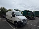 a white van parked in a parking lot next to a green truck