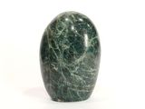 une pomme en marbre vert posée sur une surface blanche, sur fond blanc